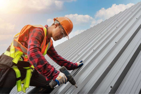 A construction worker applies metal roofing upgrades.